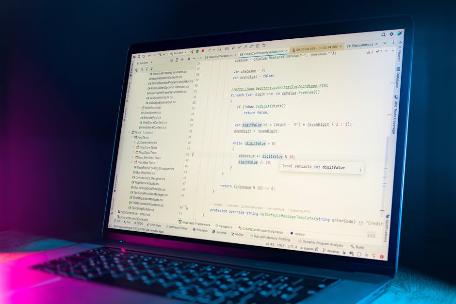 A close-up view of a modern laptop displaying lines of code in a text editor, with some code syntax highlighted in various colors. The screen shows a programming interface with code snippets, includin